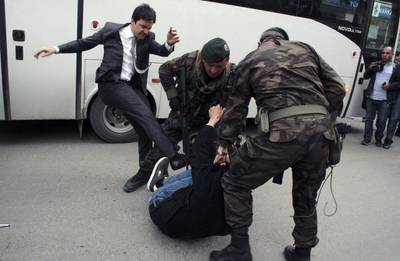 Turkish newspapers Cumhuriyet and Milliyet printed photographs they said were of Mr Erdogan’s aide, Yusuf Yerkel, kicking a protester who was on the ground and being held by special forces police. Depo Photos/AFP Photo