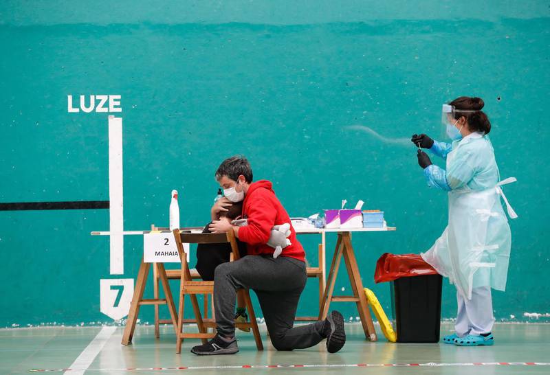 A man comforts his son after taking a coronavirus test in Getaria, Basque Country, Spain. The Basque health department has set up a text campaign in the town to try to control a possible coronavirus outbreak in the area.  EPA