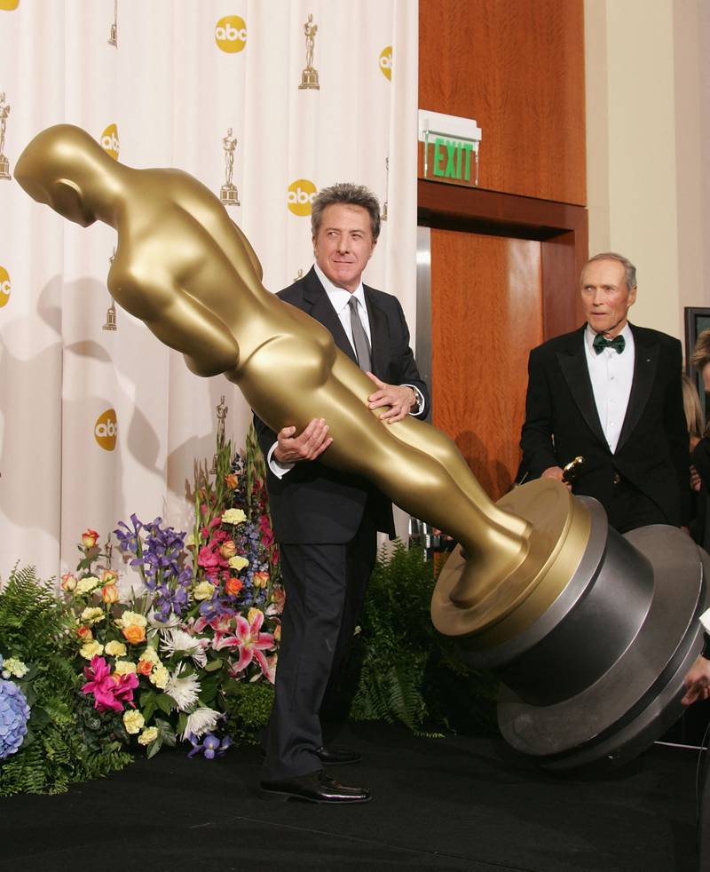 Dustin Hoffman fools around on the red carpet as director Clint Eastwood looks on at the 77th Academy Awards