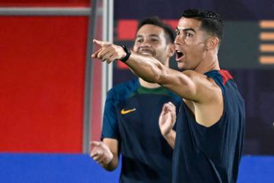 Portugal's forward #07 Cristiano Ronaldo (R) and Portugal's defender #05 Raphael Guerreiro (L) share a joke during a training session at Al Shahania SC in Al Samriya, northwest of Doha on November 27, 2022, on the eve of the Qatar 2022 World Cup football match between Portugal and Uruguay.  (Photo by PATRICIA DE MELO MOREIRA  /  AFP)
