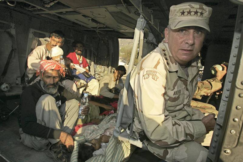 U.S. General John Abizaid, commander of the U.S. Central Command, sits aboard his helicopter about to leave Muzaffarabad, capital of Pakistan-administered Kashmir, October 23, 2005, with casualties from the South Asian earthquake. Abizaid pledged more U.S. support for relief efforts, saying the scope of the devastation was gigantic and the task ahead immense. Among the casualties who travelled with the general to the Pakistani capital Islamabad were a girl paralysed with a broken back (lying on floor in foreground) and a young boy whose mother was killed in the quake (far L). REUTERS/Zohra Bensemra - RP2DSFIXKHAA