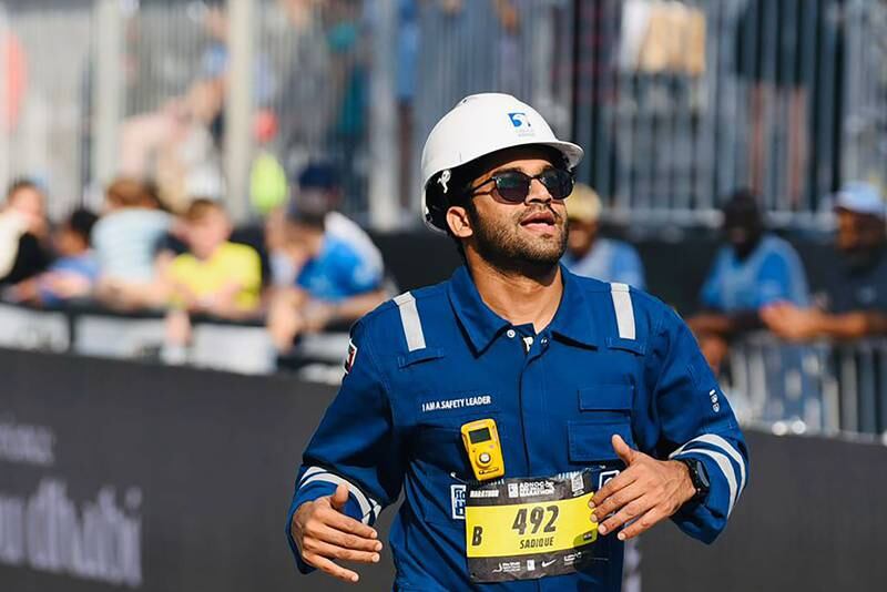 Sadique Ahmed ran the Abu Dhabi marathon on Saturday while wearing workwear to raise awareness about health and safety in the workplace. Photo: Sadique Ahmed