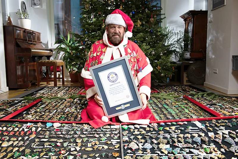 Adam Wide with his record-breaking collection of Christmas brooches and Guinness World Records certificate. Photo: Guinness World Records