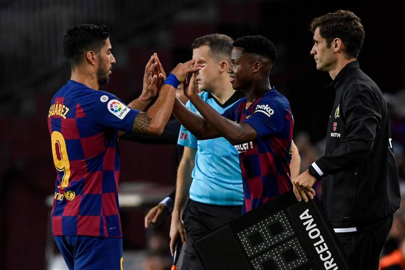 Barcelona's Uruguayan forward Luis Suarez (L) is substituted off for Barcelona´s Guinea-Bissau forward Ansu Fati during the Spanish league football match between FC Barcelona and Villarreal CF at the Camp Nou stadium in Barcelona, on September 24, 2019. / AFP / LLUIS GENE
