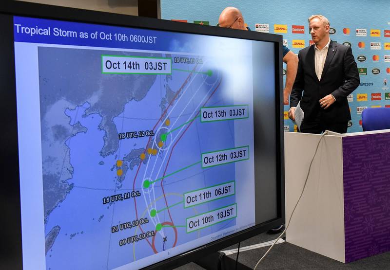 Tournament director of the 2019 Rugby World Cup Alan Gilpin walks past a screen showing the path of the approaching Typhoon Hagibis. AFP