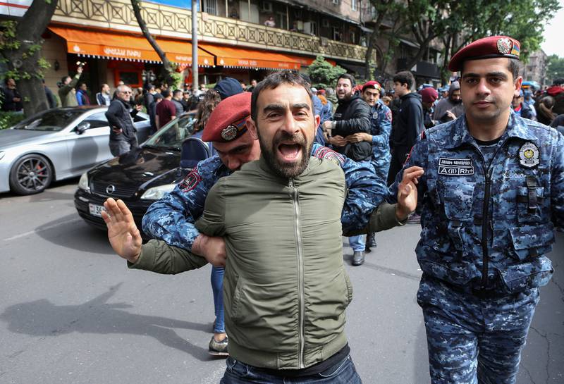 Police restrain a protester during the demonstration in Yerevan. Reuters