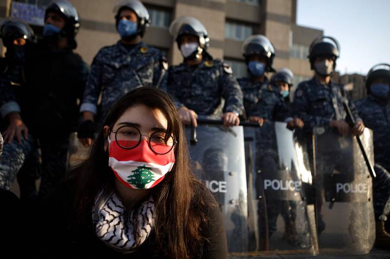 A Lebanese protester sits in front of riot police in the capital Beirut.   AFP