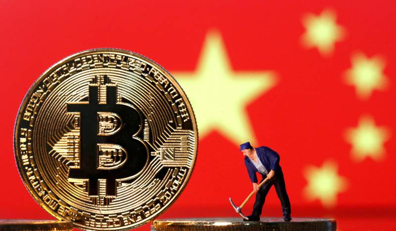 FILE PHOTO: A small toy figurine is seen on representations of the Bitcoin virtual currency displayed in front of an image of China's flag in this illustration picture, April 9, 2019. REUTERS/Dado Ruvic/Illustration/File Photo