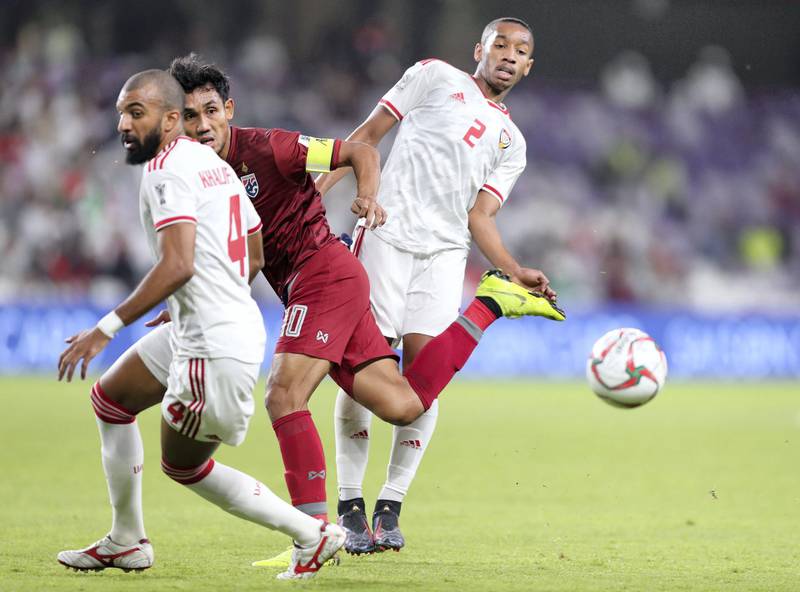 Al Ain, United Arab Emirates - January 14, 2019: Ali Hassan Ali Salmin (R) of UAE and Teerasil Dangda battle of Thailand during the game between UAE and Thailand in the Asian Cup 2019. Monday, January 14th, 2019 at Hazza Bin Zayed Stadium, Al Ain. Chris Whiteoak/The National