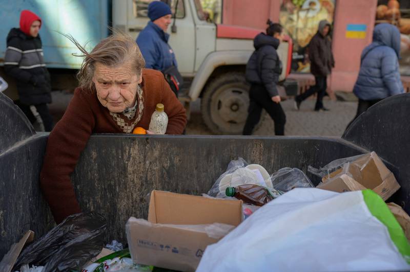 A Ukrainian woman looks for food in a bin in Odesa's city centre. AFP