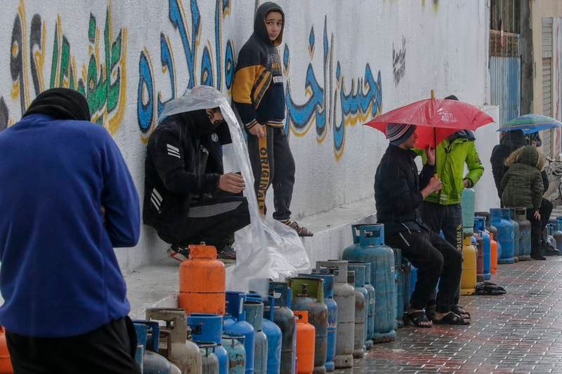 Palestinians wait to refill empty cooking gas canisters. EPA
