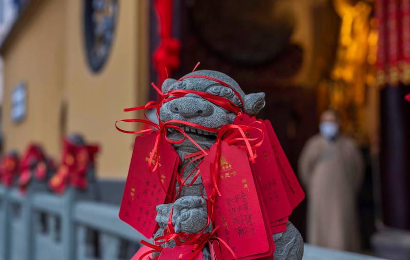 Written prayers are seen hanged on a statue in Jade Buddha Temple in Shanghai, China. EPA