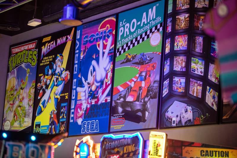 Video game artwork lines the walls of the arcade.