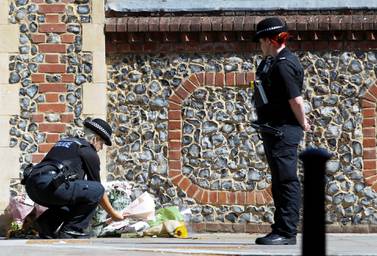 A police officer lays flowers near to the scene of reported multiple stabbings in Reading, Britain, June 22, 2020. REUTERS/Peter Nicholls