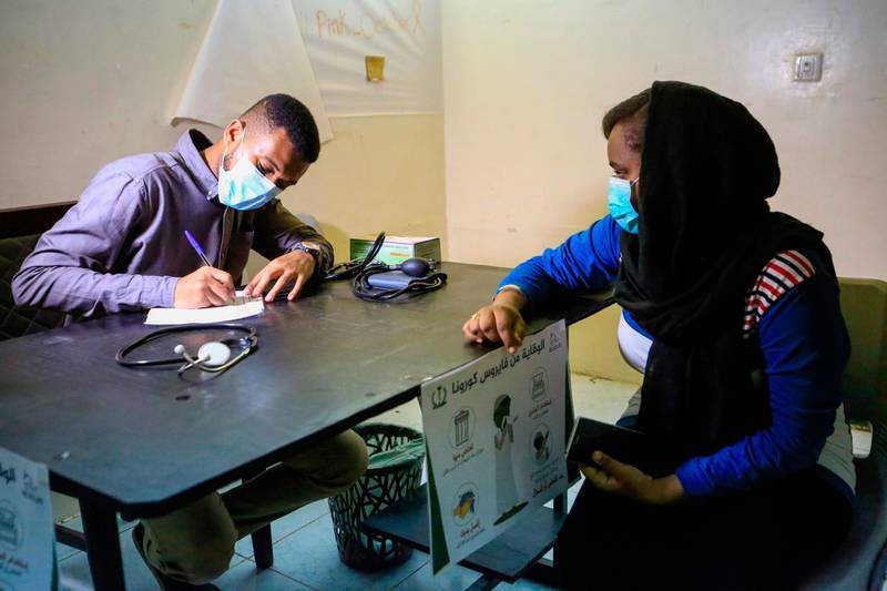A woman consults a doctor at a small treatment centre set up by local volunteers in the Shambat district of northern Khartoum, amid shortage of medicine as Sudan fights to control the spread of coronavirus.  AFP