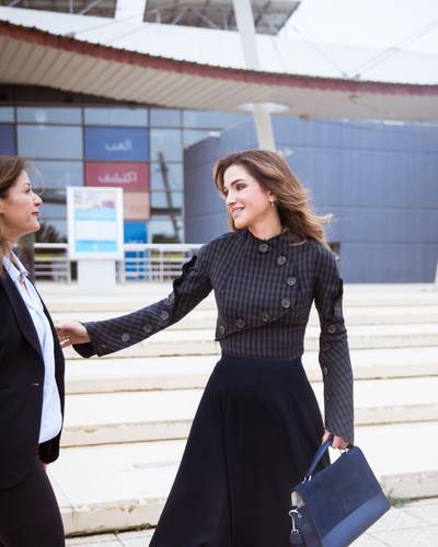Queen Rania of Jordan wore a top by A.W.A.K.E. and carried a navy blue bag by Halm. Courtesy Halm 