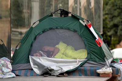 A protester sleeps in a tent as other protesters block the main highway during ongoing anti-government protests in Beirut, Lebanon.  EPA