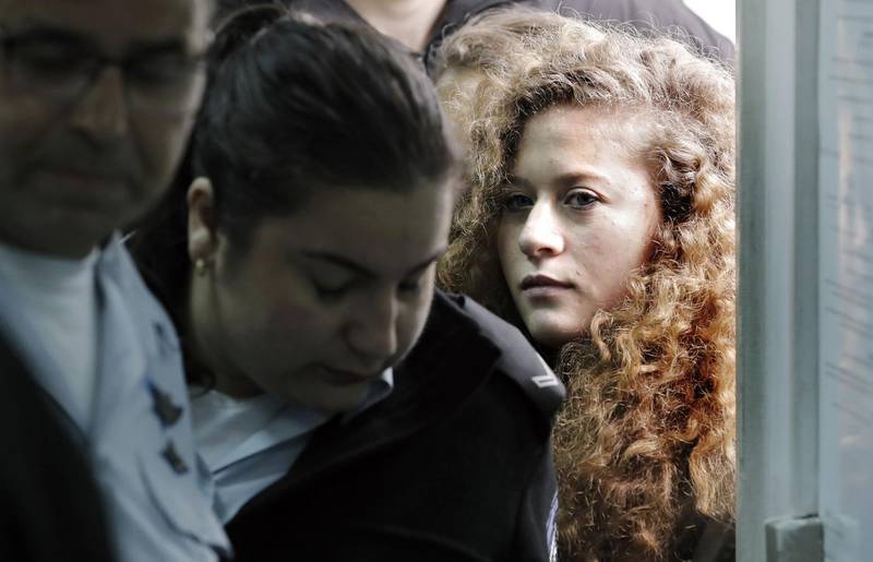 (FILES) In this file photo taken on February 13, 2018, seventeen-year-old Palestinian Ahed Tamimi (R), a well-known campaigner against Israel's occupation, arrives for the beginning of her trial in the Israeli military court at Ofer military prison in the West Bank village of Betunia. 
Tamimi who was arrested after a viral video showed her hitting two Israeli soldiers in the occupied West Bank has reached a plea deal with prosecutors to serve eight months in jail, Human Rights Watch said on March 21, 2018. / AFP PHOTO / THOMAS COEX