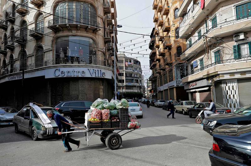 An ambulant vendor pulls his handcart in the Lebanese coastal city of Tripoli, north of Beirut, on January 26, 2021. Lebanon has imposed a round-the-clock curfew nationwide since January 14, barred non-essential workers from leaving their homes and restricted grocery shopping to deliveries. On paper, its Covid-19 restrictions are among the strictest in the world, but in reality grinding poverty is pushing many back onto the streets to eke out a living. / AFP / JOSEPH EID
