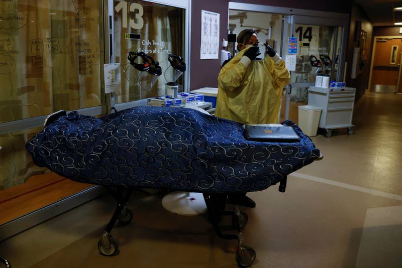 A funeral home worker puts on personal protective equipment gear before transporting the body of a deceased coronavirus patient in the US state of New Mexico this month. Reuters
