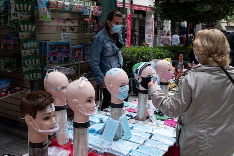 A woman buys face masks from a street vendor in Athens. AP Photo
