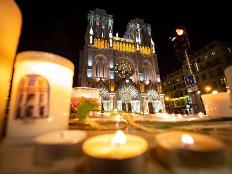 NICE, FRANCE - OCTOBER 29:  People pay tribute at night in front of Notre Dame Basilica on October 29, 2020 in Nice, France. A man armed with a knife fatally attacked people in the church, located in the heart of the city. (Photo by Arnold Jerocki/Getty Images)