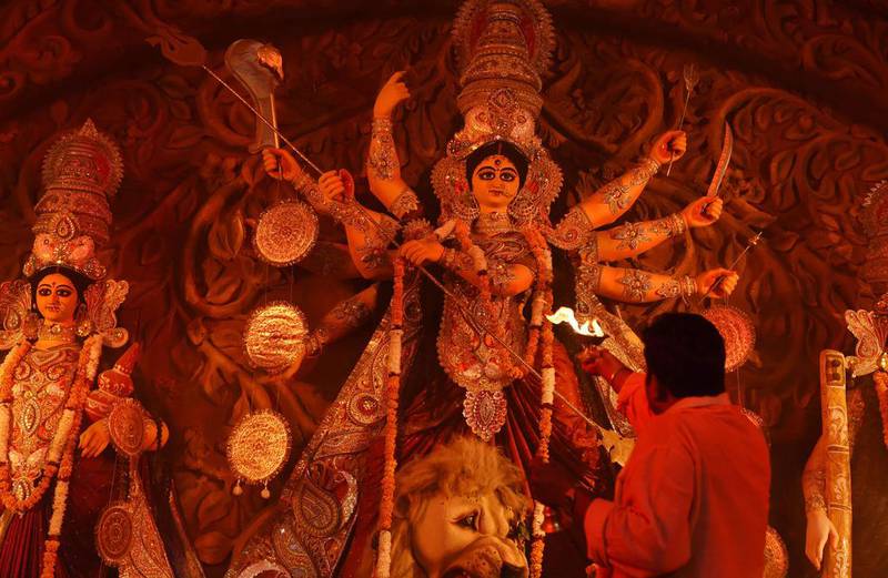 A Hindu priest offers evening prayer in front of an idol of the Goddess Durga in New Delhi.  Sajjad Hussain / AFP