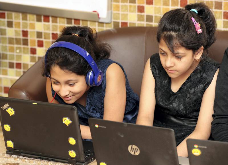 Dubai, United Arab Emirates - Reporter: Sarwat Nasir: Coronavirus / Covid-19. (R-L) Aliza Rehman aged 8 and Aiza Rehman aged 11. Pupils from low-income families receive free laptops for distance learning. Monday, May 18th, 2020. Dubai. Chris Whiteoak / The National