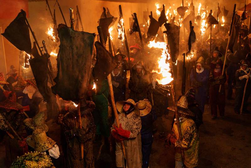 People carry torches made out of wineskins in flames during the El Vitor torch procession in Mayorga, Spain. AFP