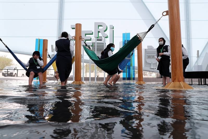 Expo visitors dip their feet in water to keep cool at the Brazil pavilion. Pawan Singh / The National