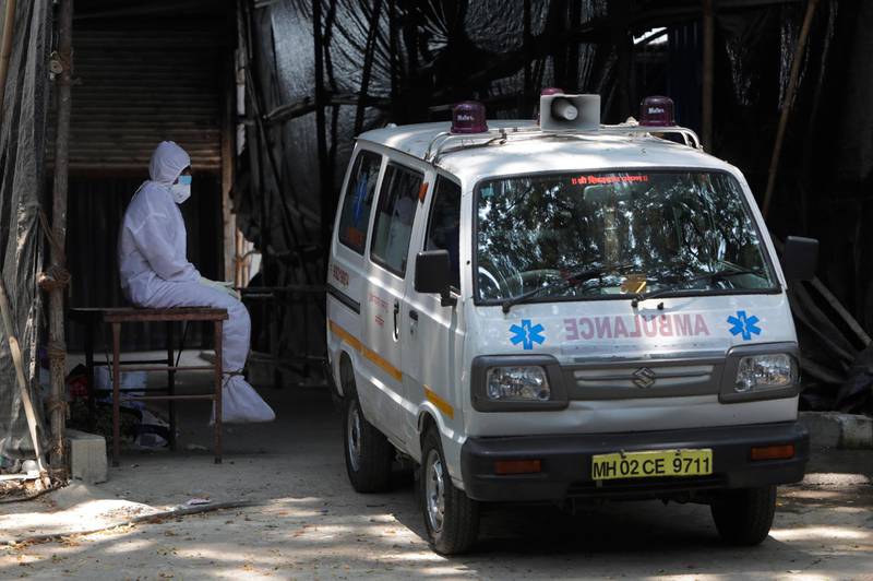 A health worker takes a break outside a field hospital in Mumbai, India. AP
