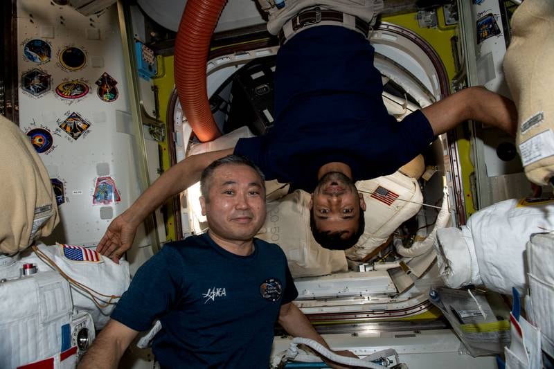 Astronaut Koichi Wakata and Sultan Al Neyadi inside the International Space Station's Quest airlock.  Nasa