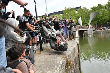 Protesters throw a statue of slave trader Edward Colston into Bristol harbour, during a Black Lives Matter protest rally, in Bristol, England, on Sunday June 7, 2020, in response to the recent death of black man, George Floyd, in Minneapolis police custody. AP