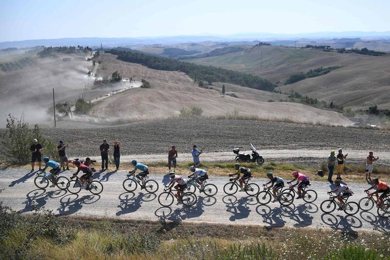 A group of riders pedal during a break away through a dusty gravel road in the one-day classic cycling race Strade Bianche (White Roads) on August 1, 2020 around Siena, Tuscany.  / AFP / Marco Bertorello
