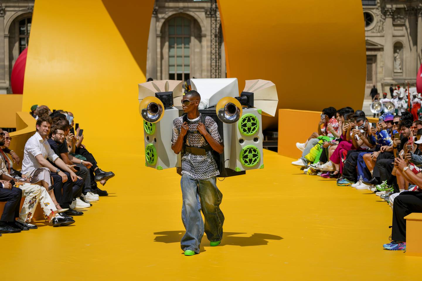 The Louis Vuitton men's spring/summer 2023 show featured a bright yellow runway, a blown-up toy racetrack that wound around a cobblestoned courtyard. AP Photo