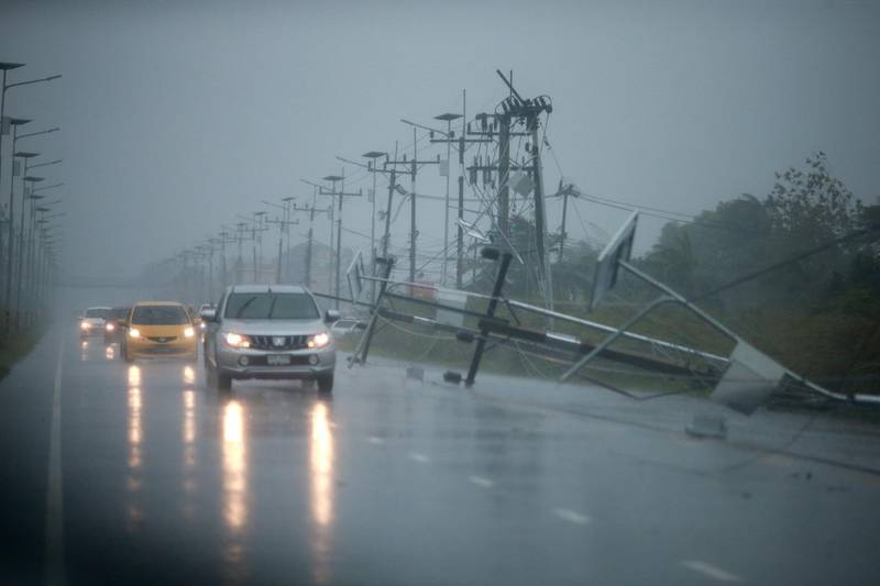 Cars and fallen electricity poles are seen along a road as tropical storm Pabuk approaches the southern province of Nakhon Si Thammarat, Thailand. Reuters