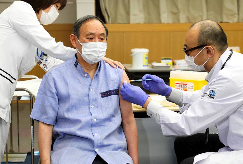 Japan's Prime Minister Yoshihide Suga (C) receives the COVID-19 vaccine at the National Center for Global Health and Medicine in Tokyo on March 16, 2021. (Photo by JAPAN POOL VIA JIJI PRESS / JIJI PRESS / AFP) / JAPAN OUT