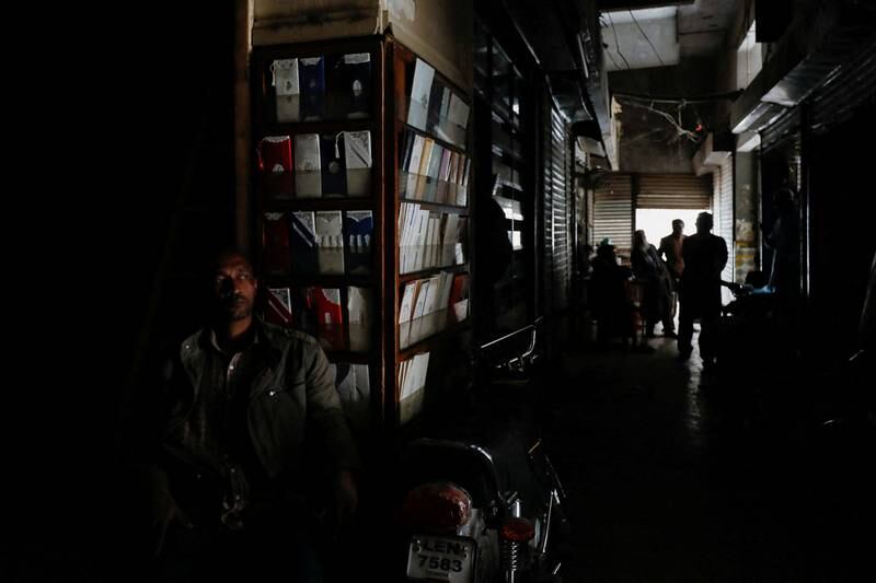 A shopkeeper sits in near-darkness in Karachi. The blackout raised questions about the government's handling of the situation. Reuters