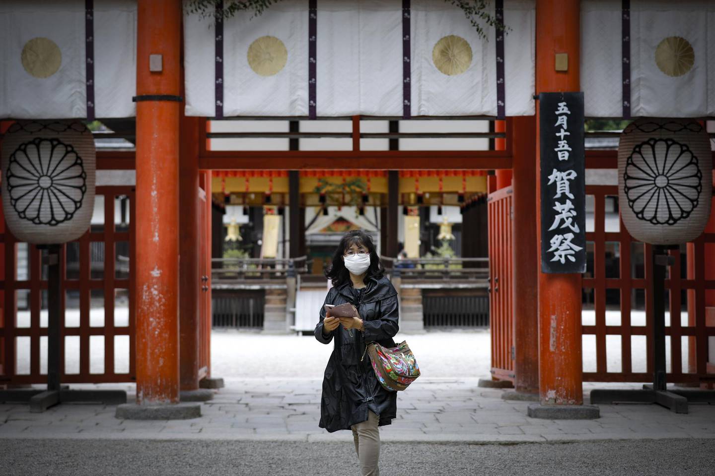 epa08423615 A woman wearing a face mask looks on at Shimogamo Shrine in Kyoto, Japan, 15 May 2020. The streets of Japan's ancient imperial capital and its world-famous tourist spots are largely deserted as the number of foreign visitors has plummeted by more than 93 percent compared to last year, local media reported in late April. Japan's tourism industry has been hit hard by the ongoing COVID-19 pandemic, putting millions of tourism-dependent jobs at risk. Kyoto is one of prefectures that remain in a state of emergency the government imposed in a bid to curb the spread of the coronavirus SARS-CoV-2 which causes the COVID-19 disease. Japan on 14 May 2020 lifted the measure in most parts of the country.  EPA/DAI KUROKAWA