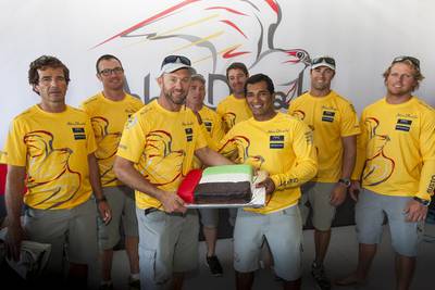 Abu Dhabi Ocean Racing's Ian Walker, skipper of the Azzam, presents ADOR team sailor Adil Khalid with a birthday cake. Ian Roman / Abu Dhabi Ocean Racing / October 7, 2014 
