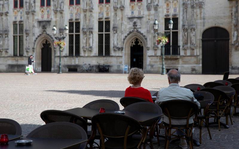 A couple sit on the empty terrace of a restaurant in a historic square of Bruges, Belgium. AP Photo