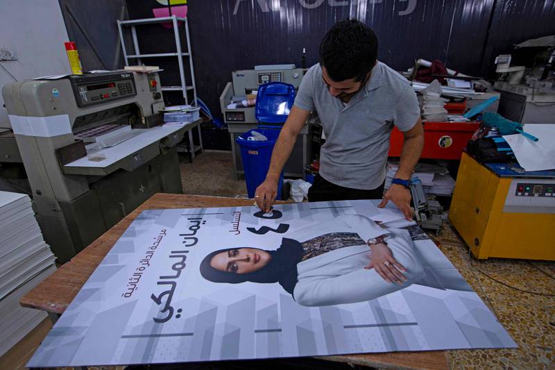 A worker prepares a campaign poster in Iraq's southern port city of Basra on September 12, 2021, ahead of the upcoming parliamentary elections.  (Photo by Hussein FALEH  /  AFP)
