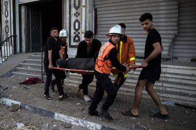 Palestinian rescuers move an elderly woman from a building in Gaza City after Israeli air strikes in the area. AP Photo