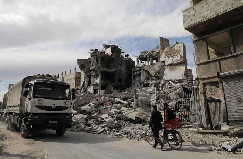 A humanitarian convoy organised by the Syrian Arab Red Crescent in cooperation with the International Committee of the Red Cross and the UN enters Douma, the main town in Eastern Ghouta, on March 15, 2018. Hamza Al Ajweh / AFP
