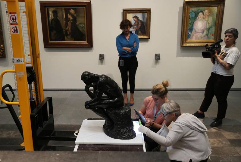 Dr Souraya Noujaim, the Scientific, Curatorial and Collections Management Director, who is the person in charge of all of Louvre Abu Dhabi's collection, center back, supervises the examination of Rodin's 'Thinker' bronze statue after removal from it's package to install it at the Louvre Museum in Abu Dhabi. Kamran Jebreili / AP photo