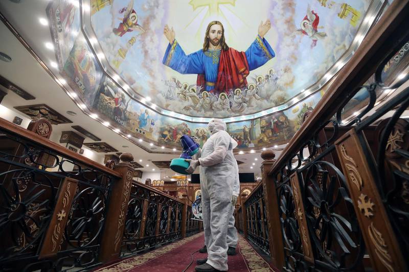 A member of a medical team sprays disinfectant at a church in Cairo. EPA