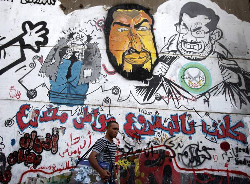 A man walks past graffiti depicting ousted Egyptian President Mohammed Morsi, right, and the Deputy Guide of the Muslim Brotherhood Khairat Al Shater in downtown Cairo, Amr Abdallah Dalsh / Reuters