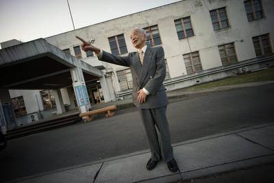 Yoshiomi Yanai stands in front of Tsukuba Naval Air Group Base.