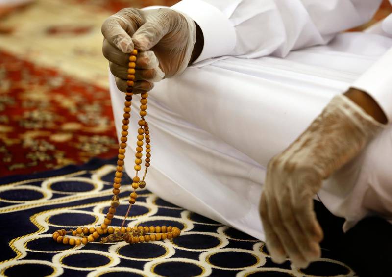 A worshipper wearing surgical gloves to prevent the spread of Covid-19 prays at Al Mirabi Mosque in Jeddah, Saudi Arabia. AP Photo