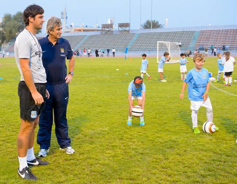 Manchester City Football Club manager Manuel Pellegrini, right, and star midfielder Samir Nasri at a coaching session at the Manchester City Football School in Abu Dhabi. Courtesy City Football Schools